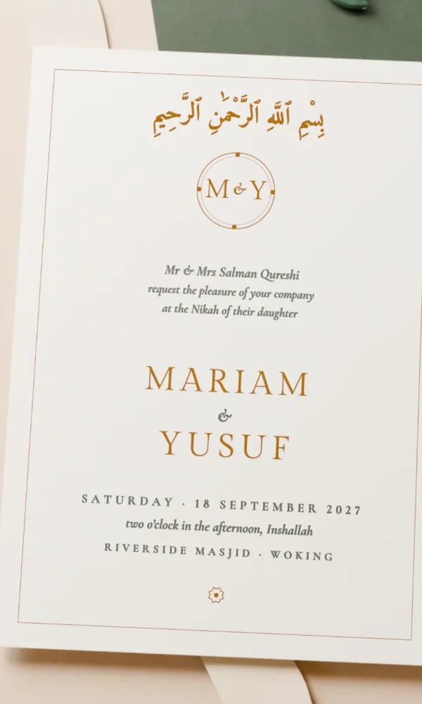 The Ivory Card as Monogram: the couple’s initials in a gold roundel, their names in capitals