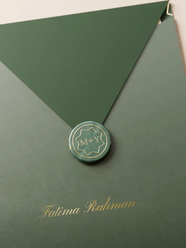 An emerald envelope sealed with the couple’s initials, “Fatima Rahman” written below the seal